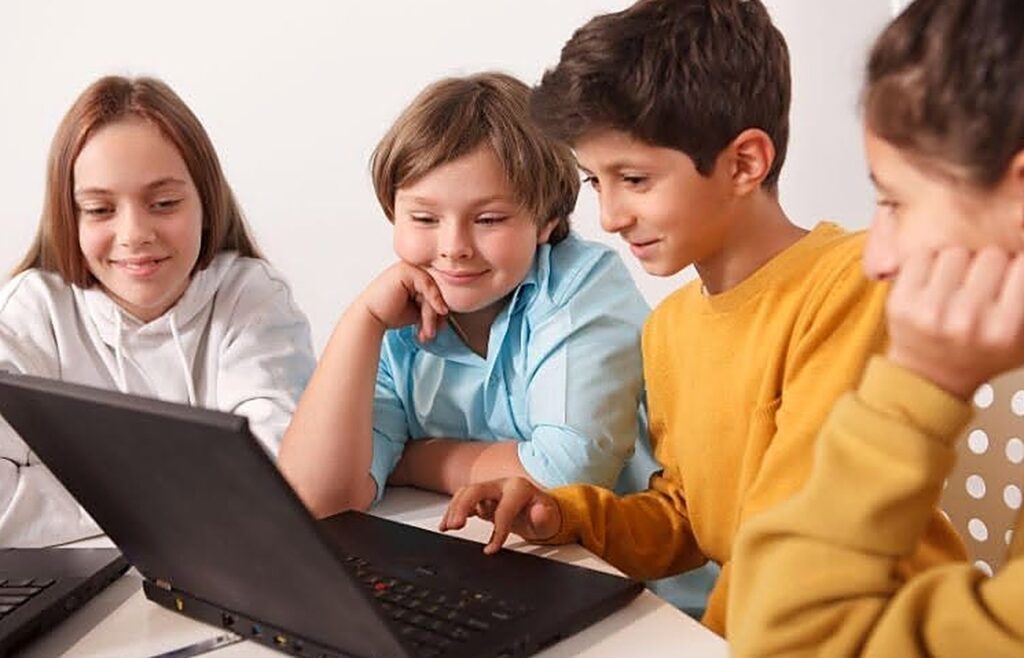 Niños y jóvenes usando una computadora portátil